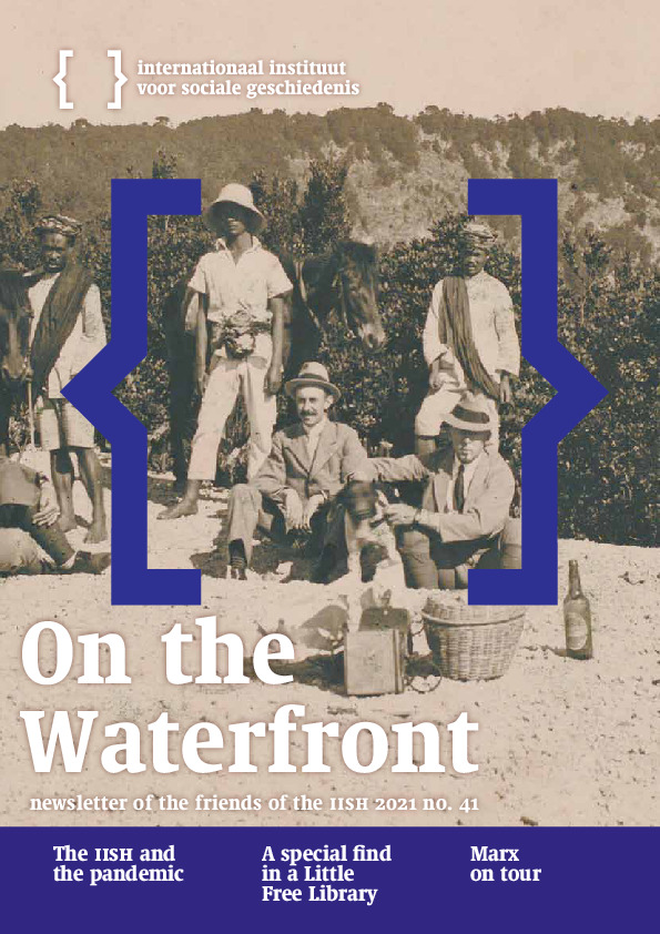 Cover of On the Waterfront 41. A black-and-white photograph from the 1950s showing two European men on a picnic in the Dutch East Indies, with three native servants and two horses in the background.