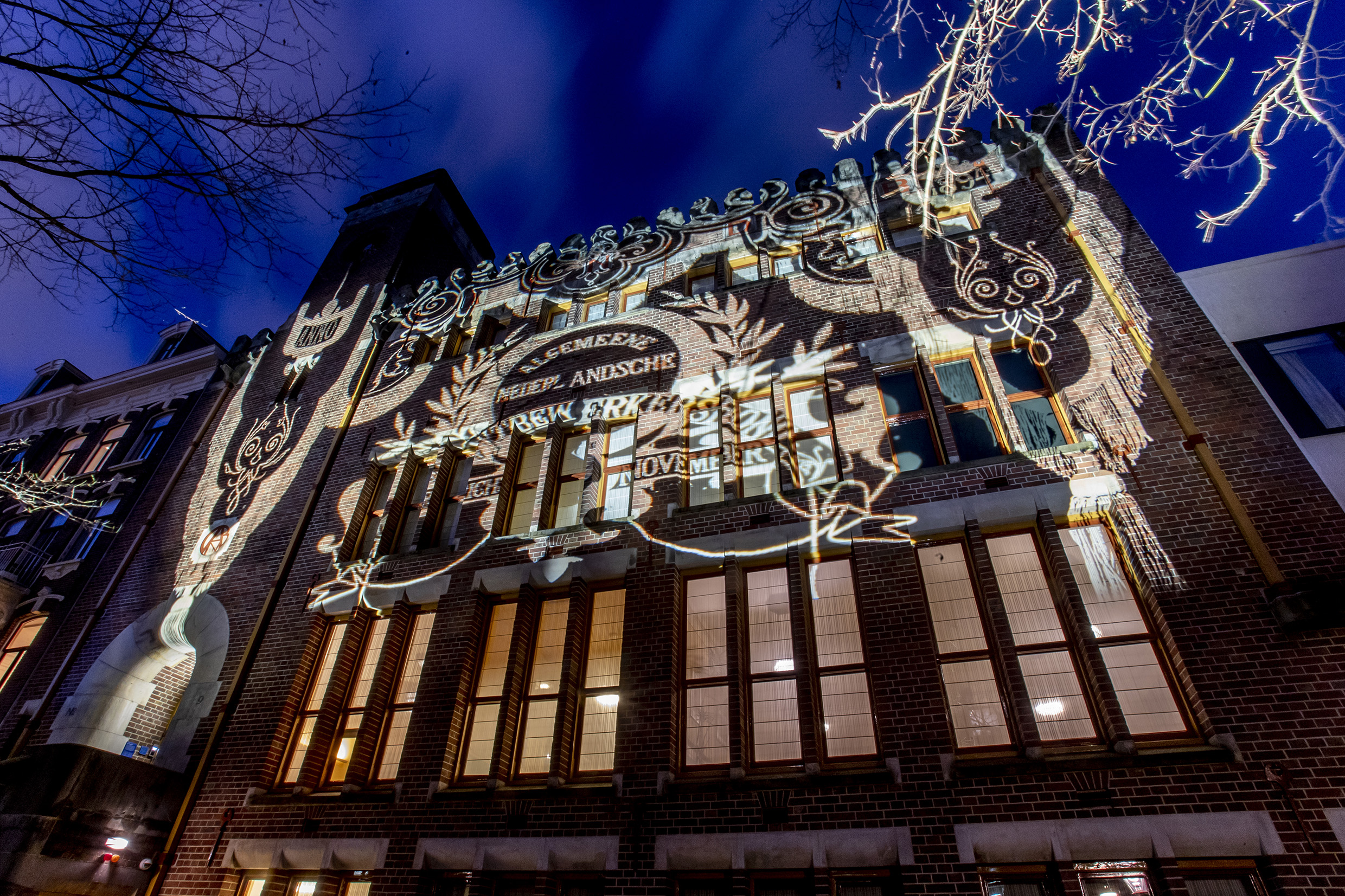 Op de foto is de Burcht te zien, het bondskantoor van de Algemeene Nederlandsche Diamantbewerkersbond (ANDB). Op het grote gebouw, gefotografeerd in het donker, is een lichtkunstwerk te zien. 