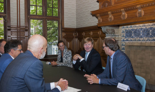 an image of king Willem Alexander and the directors of the HuC institutes in the commisariskamer at the spinhuis.